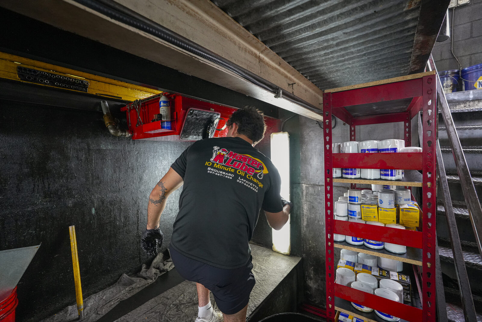 Master Lube technician working beneath a vehicle in the service bay