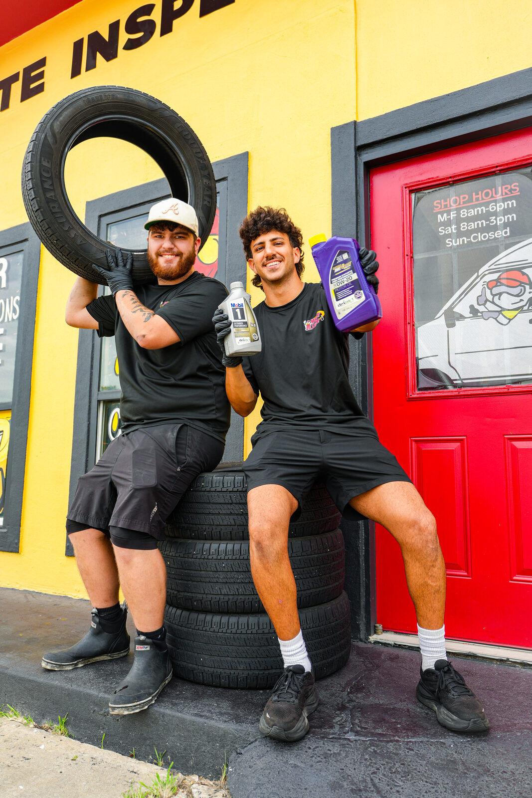 Master Lube team members with tires and motor oil outside the shop
