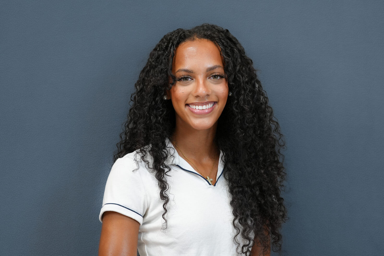 Studio headshot, female subject, white polo