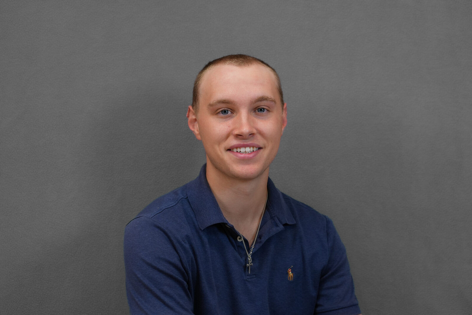 Studio headshot, male subject, navy polo