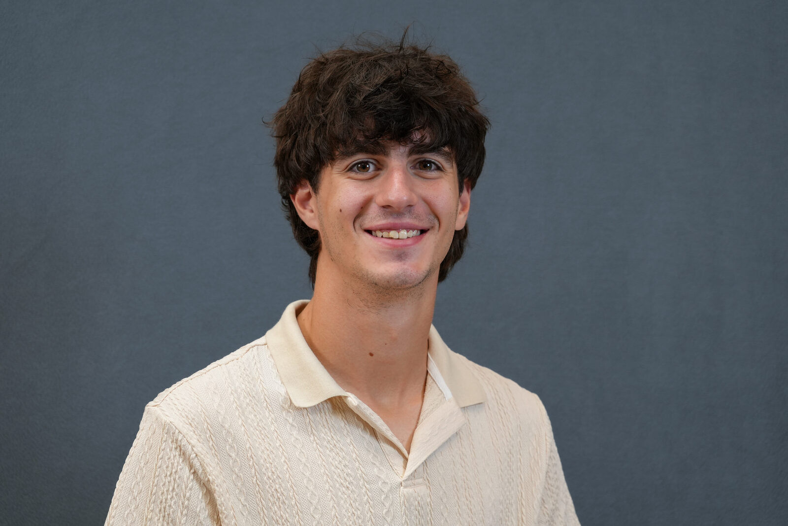 Studio headshot, male subject, cream sweater