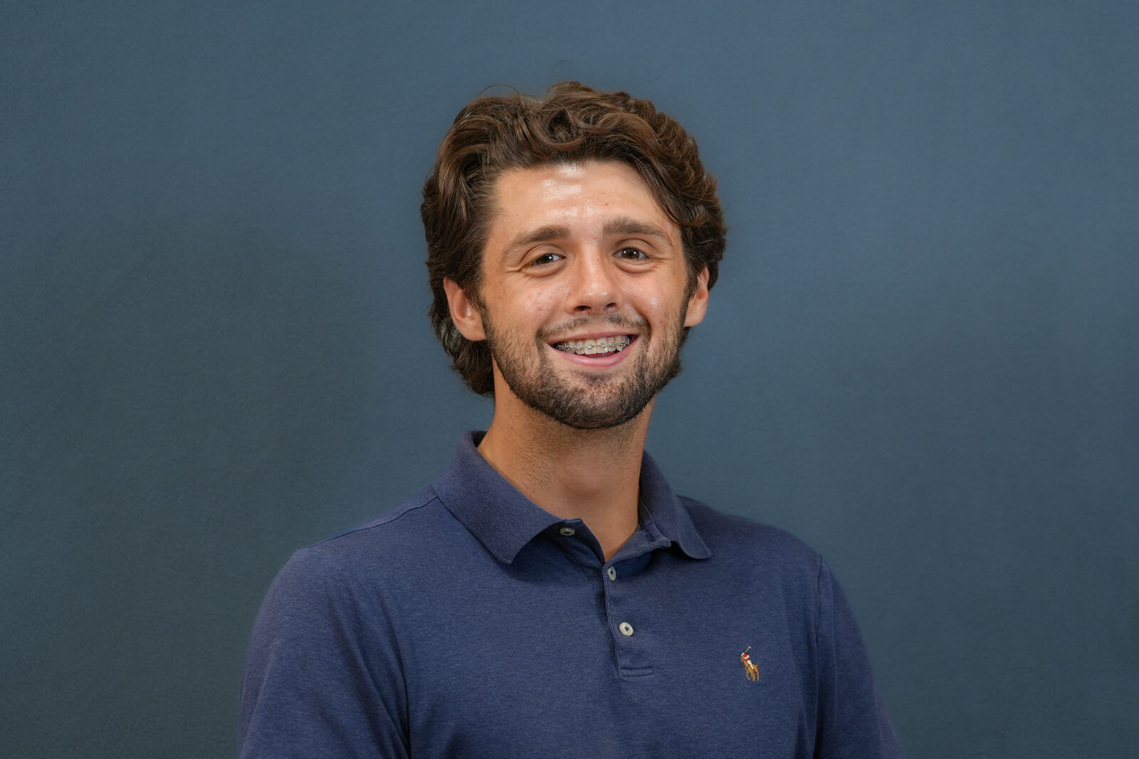 Studio headshot, male subject, navy polo