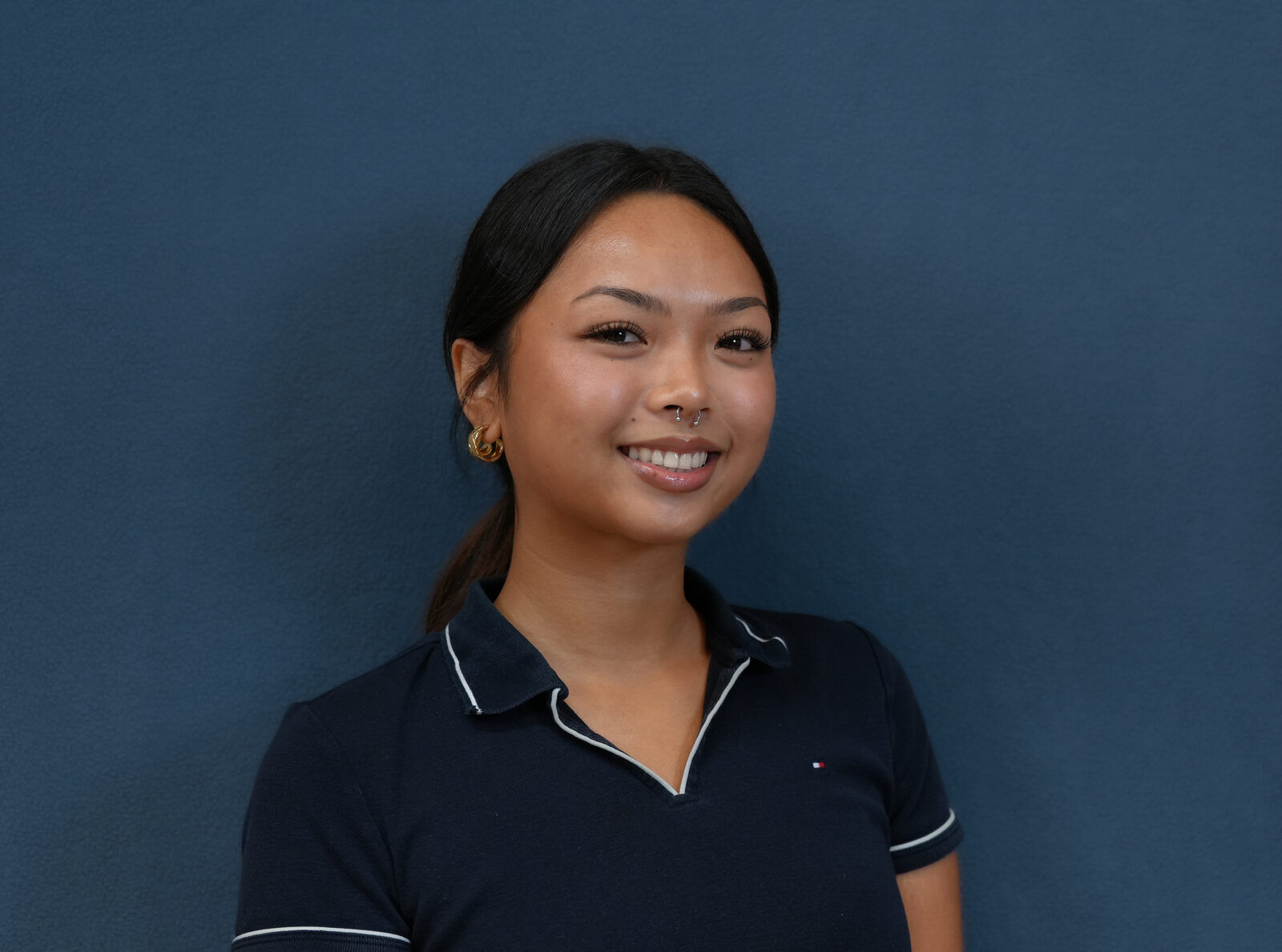 Studio headshot, female subject, navy polo