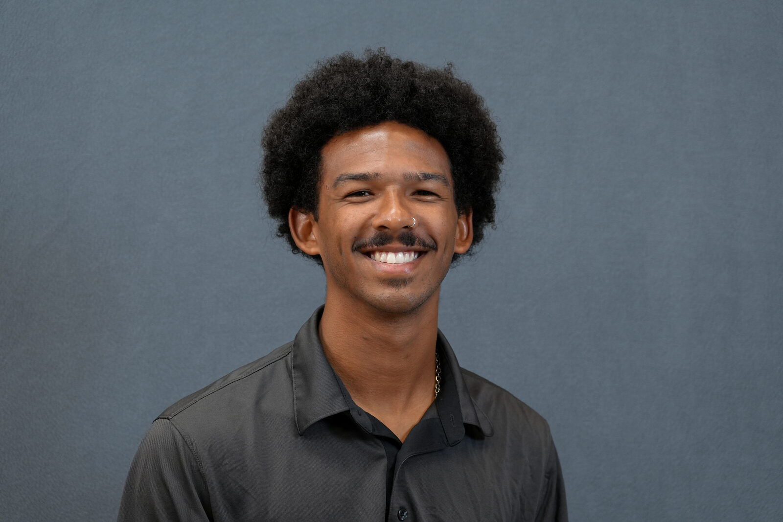 Studio headshot, male subject, dark shirt